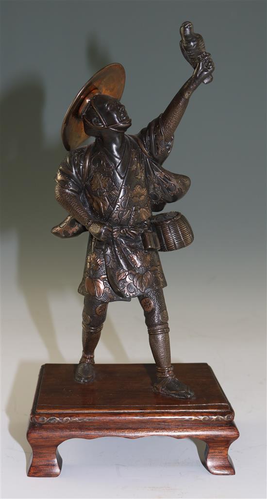 A Japanese two-colour bronze figure of a falconer, by Miyao, Meiji period, total height 26cm, lacking item to left hand